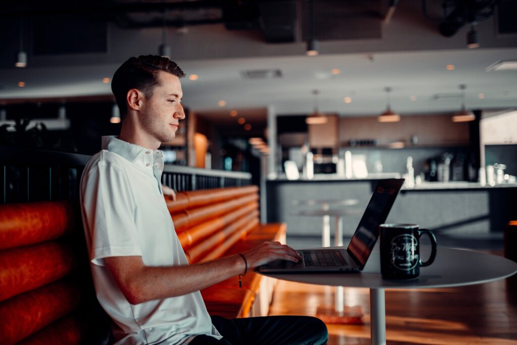 男性がカフェに一人でパソコンを操作している写真